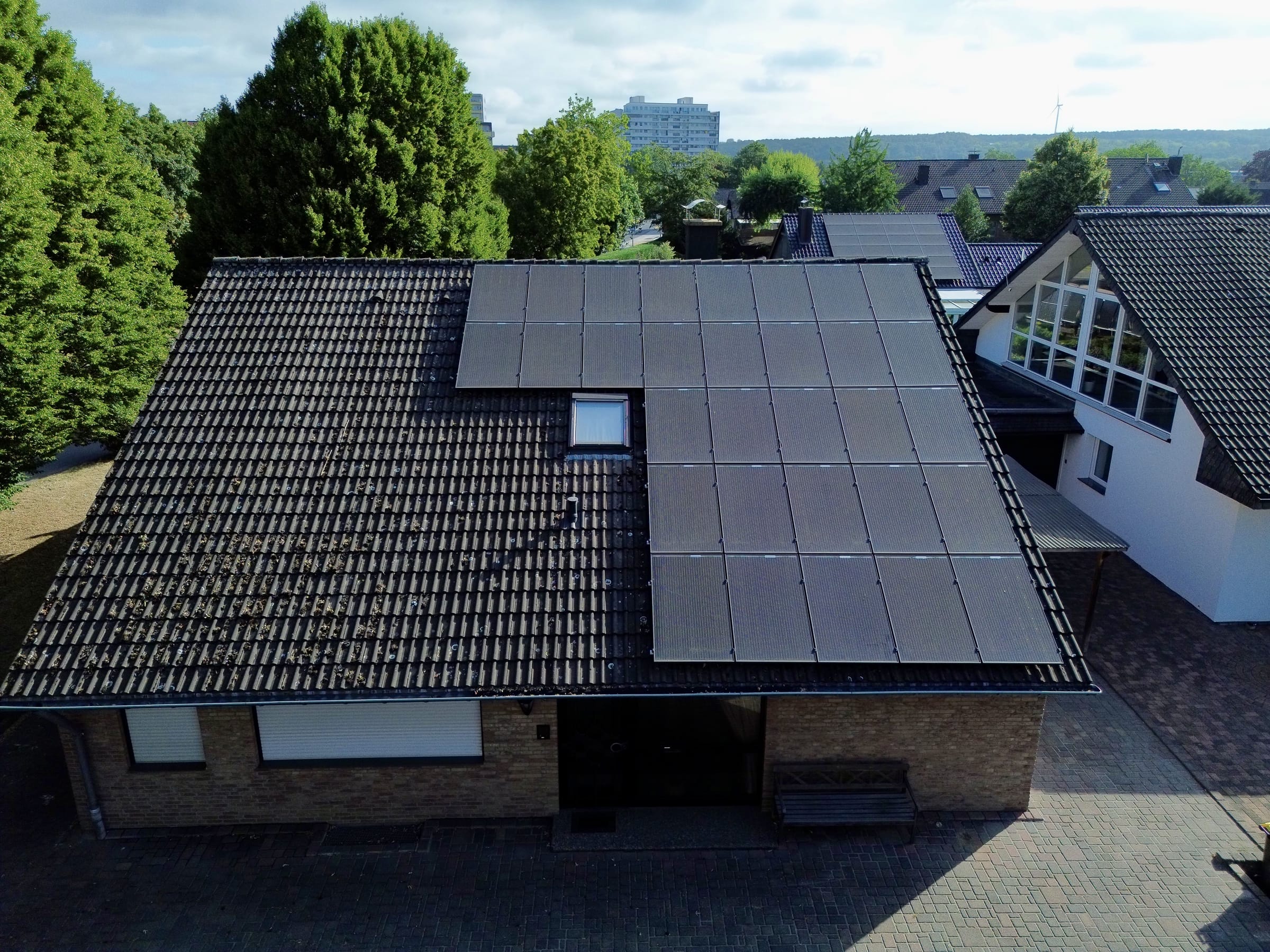 Satteldach eines Wohnhauses mit Photovoltaikanlage vor der Bearbeitung: dunkles, stark verschmutztes Ziegeldach.